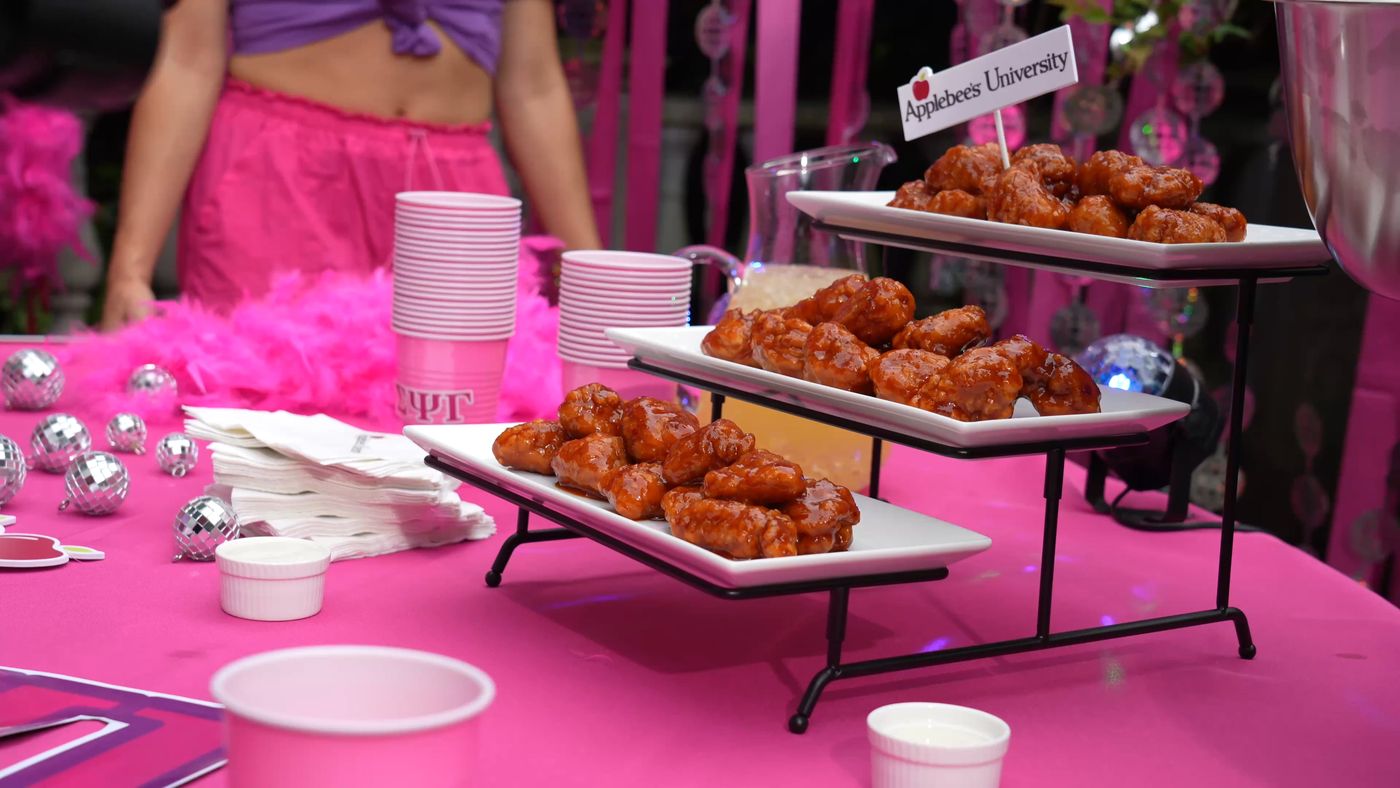 A tiered display of Applebee's boneless wings at an “Applebee's University” branded campus event, part of the AYCE Rush campaign.