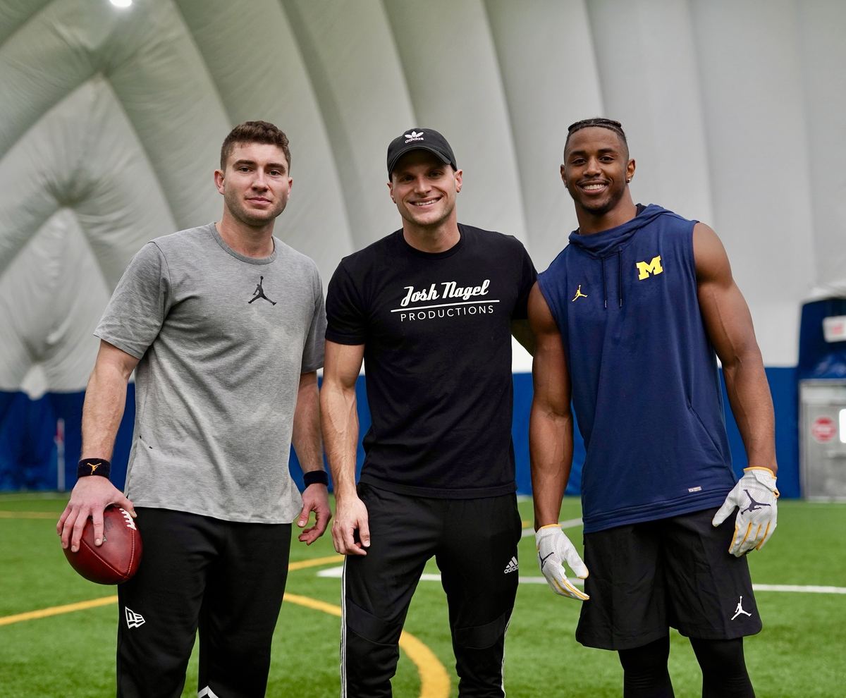 Josh Nagel with two athletes at an indoor training facility, University of Michigan gear visible, during the Donovan Peoples-Jones NFL Pro Day shoot.