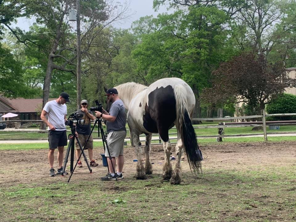 Josh Nagel and crew filming a horse on location during a documentary production.