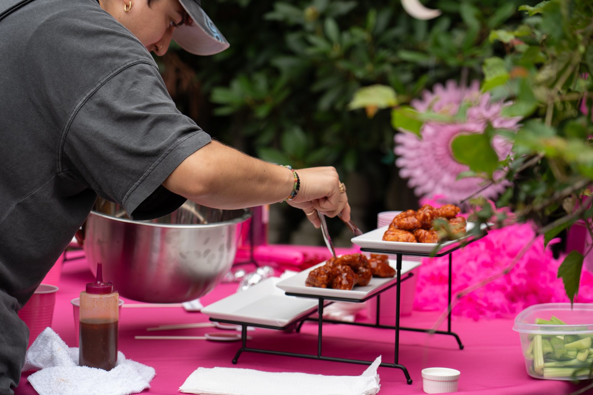 Food is arranged on tiered plates on the pink set for an Applebee’s production.