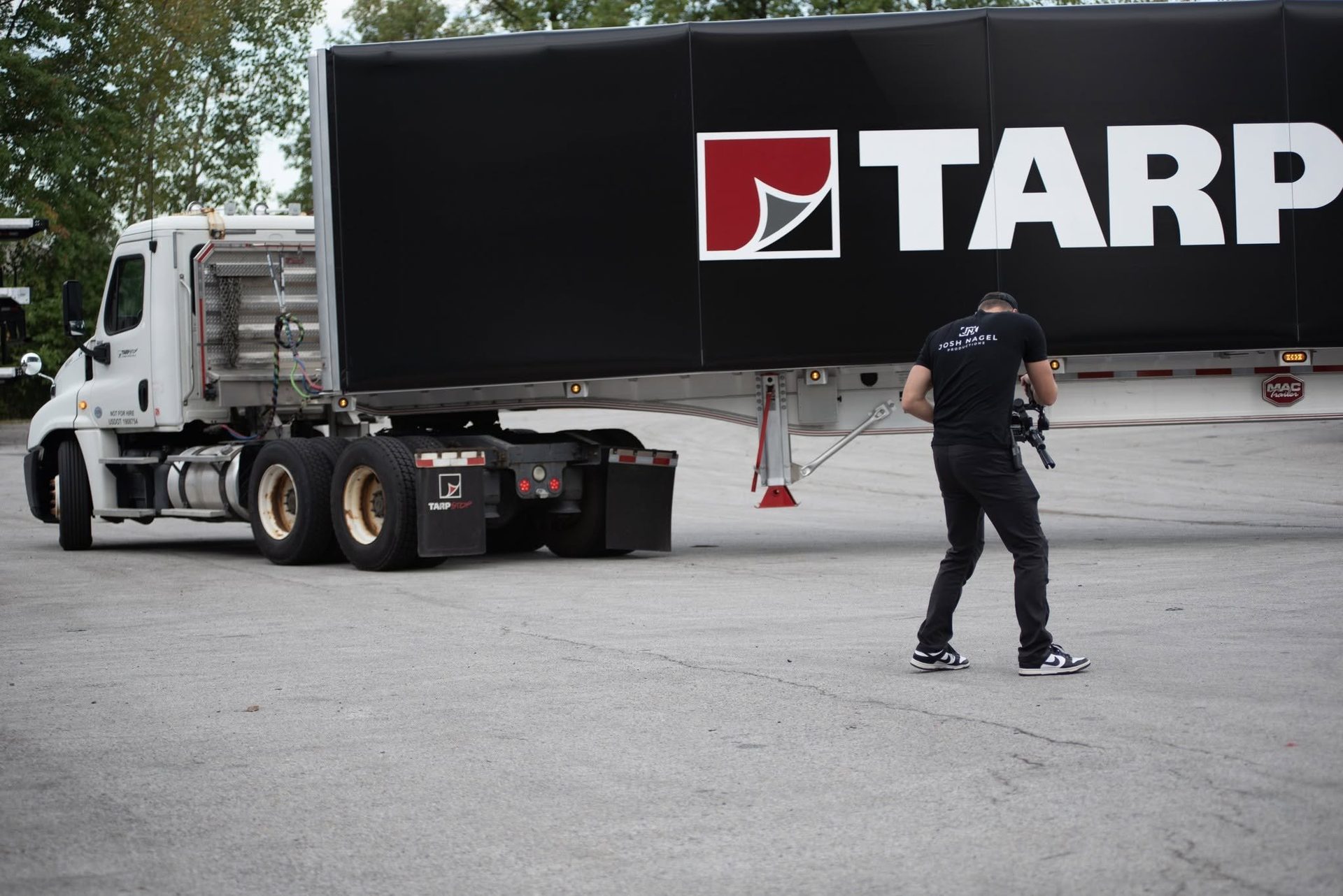 A camera operator films a tractor-trailer on location for the Tarpstop FasTrak II promo.